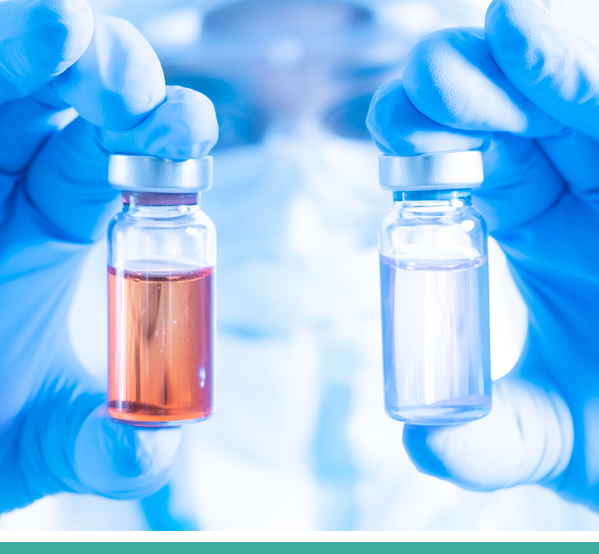 Gloved hands holding two medical vials.