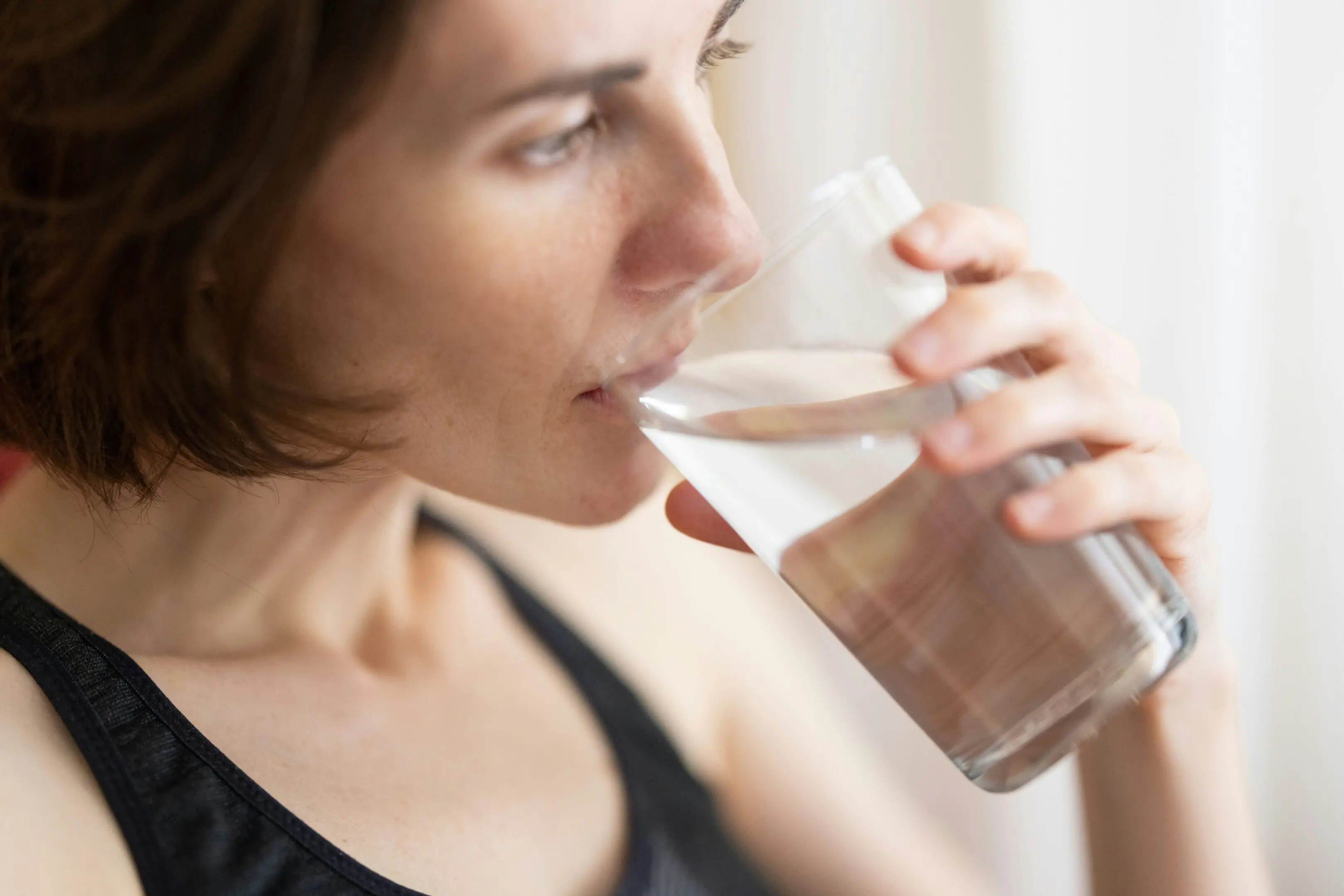 A woman drinking a glass of water.
